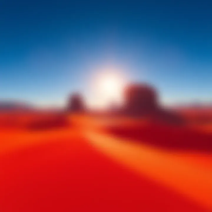 Vast red sands and rocky formations under a clear blue sky in the Crimson Desert