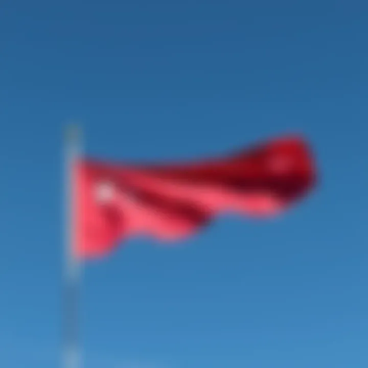 A flag flown at half-mast to signify mourning or respect, set against a clear blue sky.