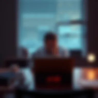 A person sitting at a desk with a laptop and a timer set for three hours, concentrating on their work.