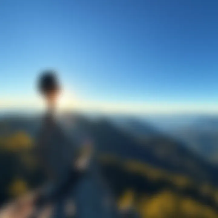 Hiker enjoying a view from a mountain A hiker stands on a rocky outcrop, gazing at a stunning valley filled with trees and mountains under a clear blue sky