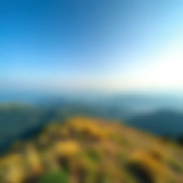 A panoramic view from the top of a hill in Liurnia, showcasing green valleys and distant mountains under a clear sky