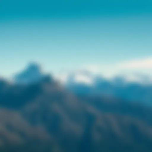 A breathtaking view of tall mountains with snow-capped peaks under a clear blue sky, showcasing the beauty of nature.