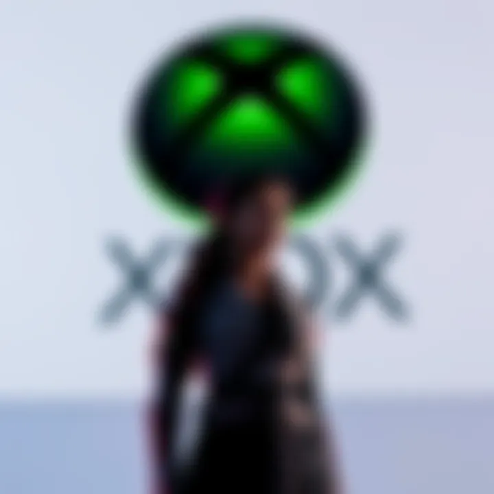Microsoft Gaming Division Asha stands in front of Xbox logo, contemplating changes in gaming strategy after recent layoffs.