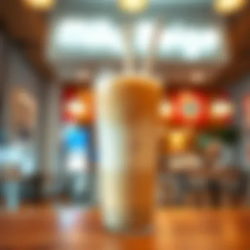 A creamy Milk Tea Beige drink in a clear cup with a straw, set against a welcoming eta shop background.