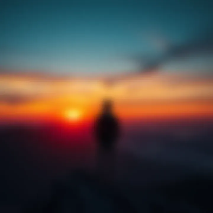 A person stands on a mountain, gazing at a sunset, evoking feelings of nostalgia and longing for home.