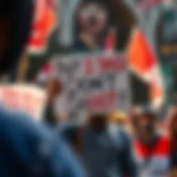 A protestor stands firmly holding a sign that reads 'But I Said Don't Shoot!' during a community rally, surrounded by other demonstrators showing solidarity.