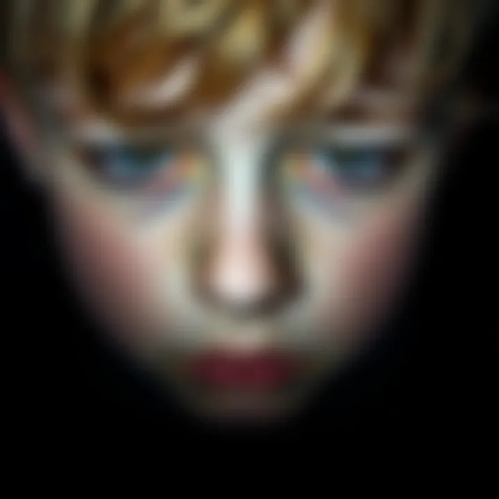 Close-up of a young boy with sad eyes looking down, reflecting his difficult situation.