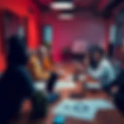 A group of diverse team members discussing strategies around a table with laptops and charts during a launch planning meeting.